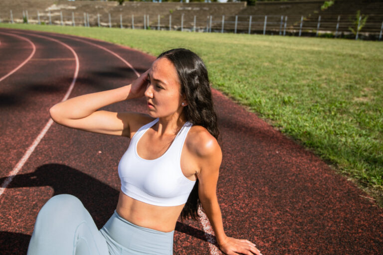 Woman resting on a running track after a workout
