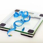 Glass bathroom scale with a blue measuring tape