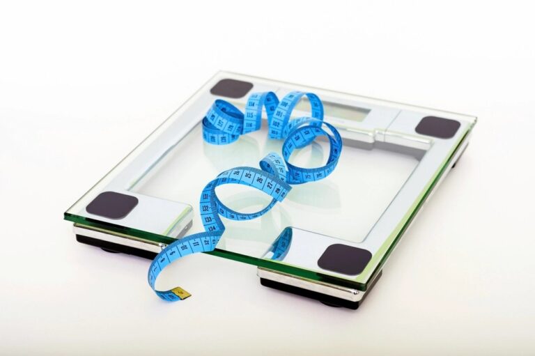 Glass bathroom scale with a blue measuring tape